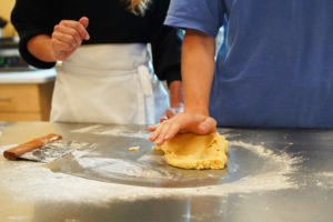 Dragonfly Café kitchen employees work together to knead dough